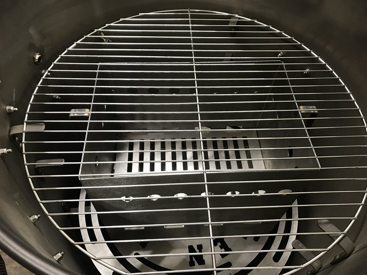 Place the fire basket on the heat deflector plate to grill in the Ultimate Drum Smoker