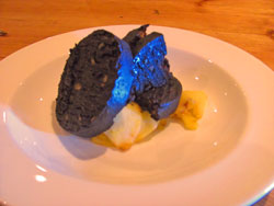 Black pudding served on a bed of caramelized apple