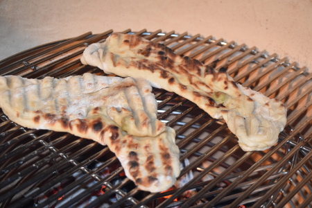 Flat breads grilling directly over charcoal