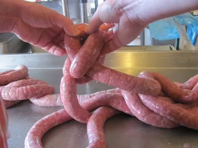 Pull a length of sausage through to create the butchers link