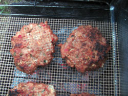 grilled venison burgers over charcoal