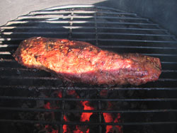 Smoked pork tenderloin being seared on the grill